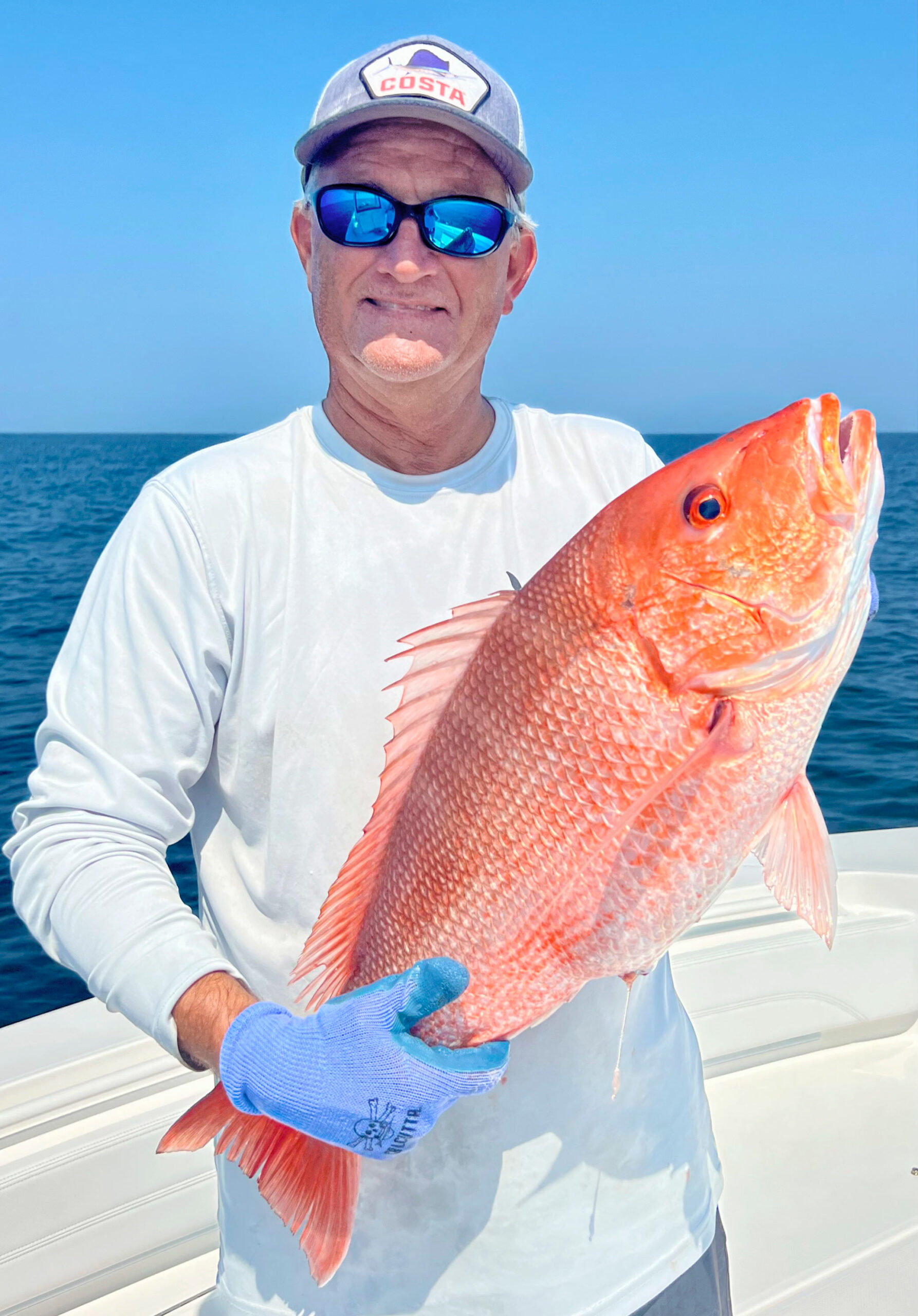 David Ritchie wearing sunglasses and holding a red snapper.