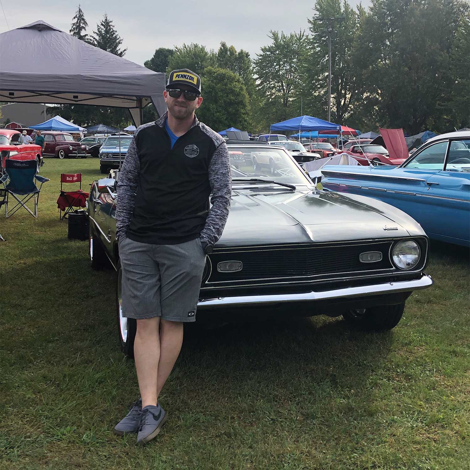 A man leaning against a vintage car.