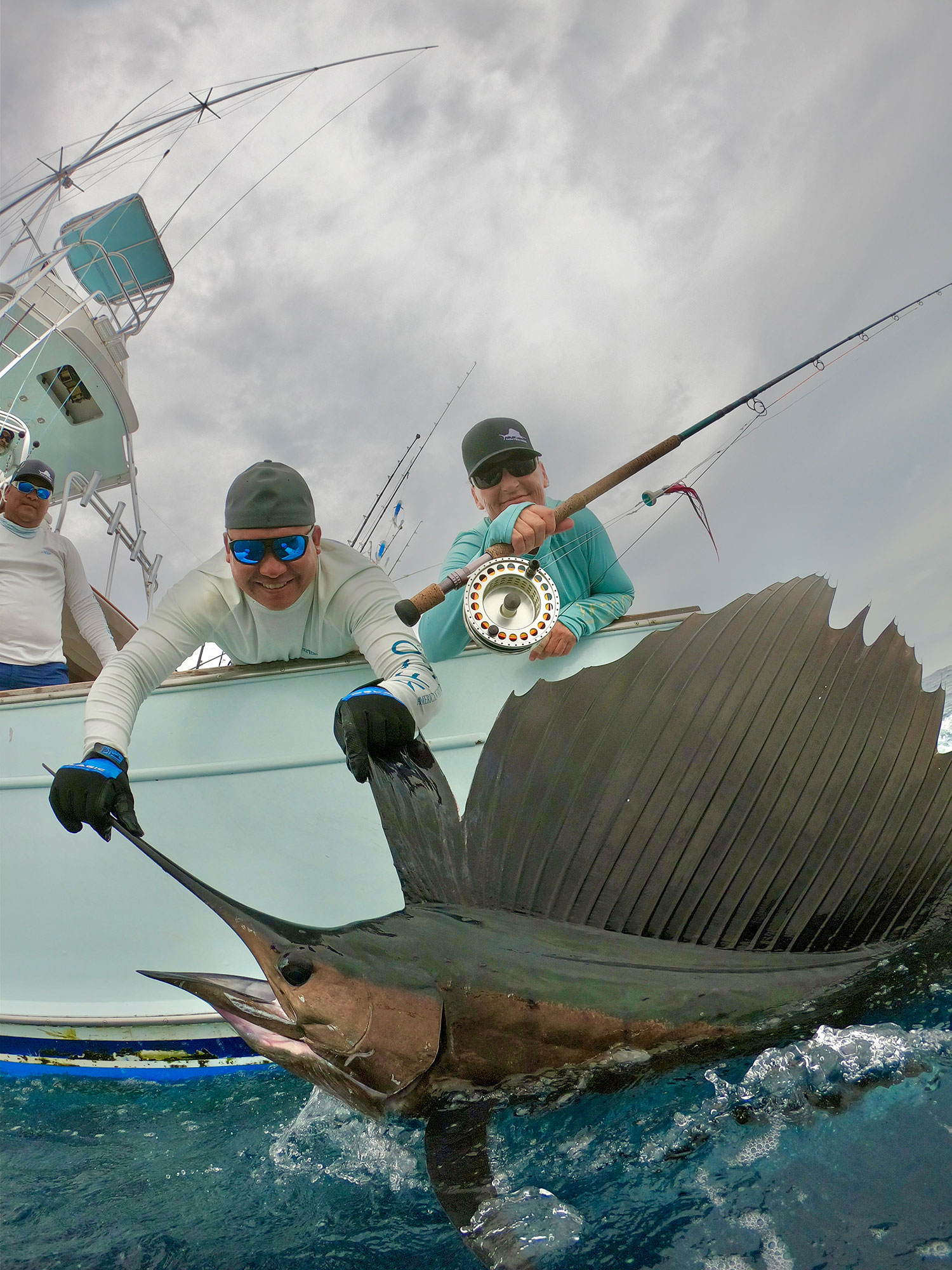 Capt. Jen Copeland pulling a large sailfish boatside with the help of a crewmate.